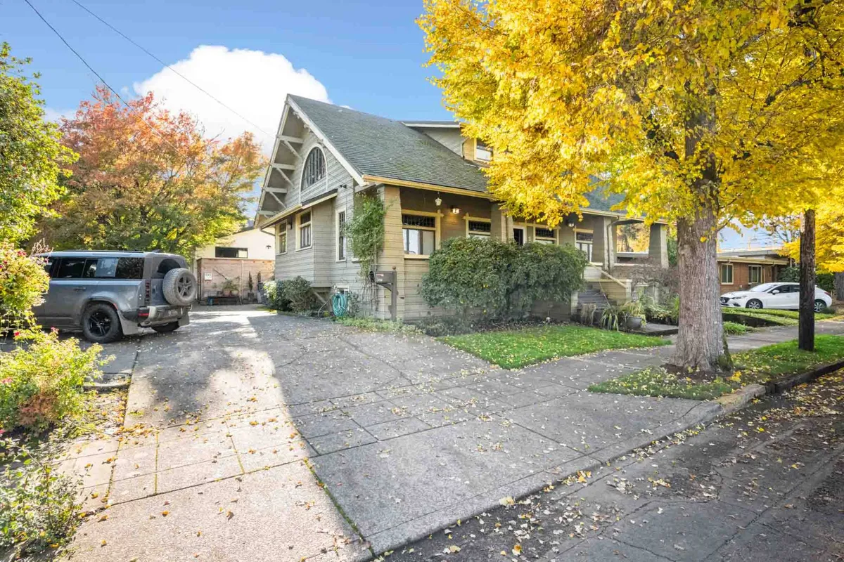 A charming house facade framed by vibrant yellow autumn leaves, with a driveway leading up to the entrance. The scene exudes warmth and welcomes, hinting at the home's inviting character and seasonal appeal.