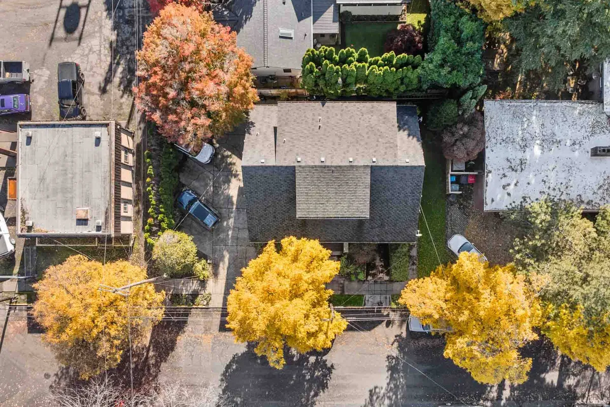 A wide-angle exterior shot highlights the colorful autumn trees surrounding the house, the roofline, and the peaceful neighborhood. The image radiates warmth and seasonal beauty, hinting at outdoor family activities and a safe environment.